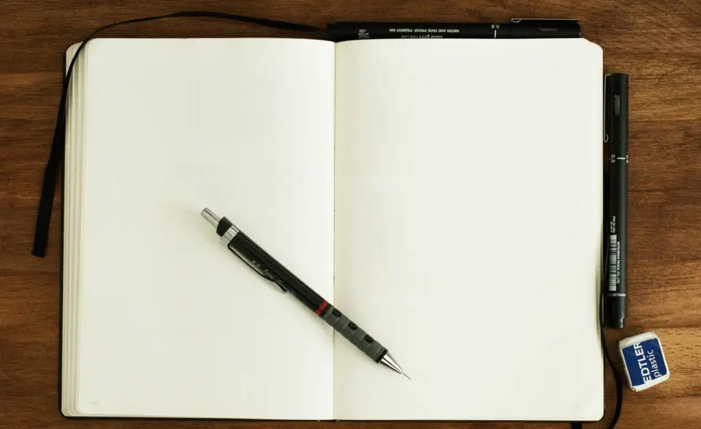 Leeg notitieboek met een pen op een houten tafel