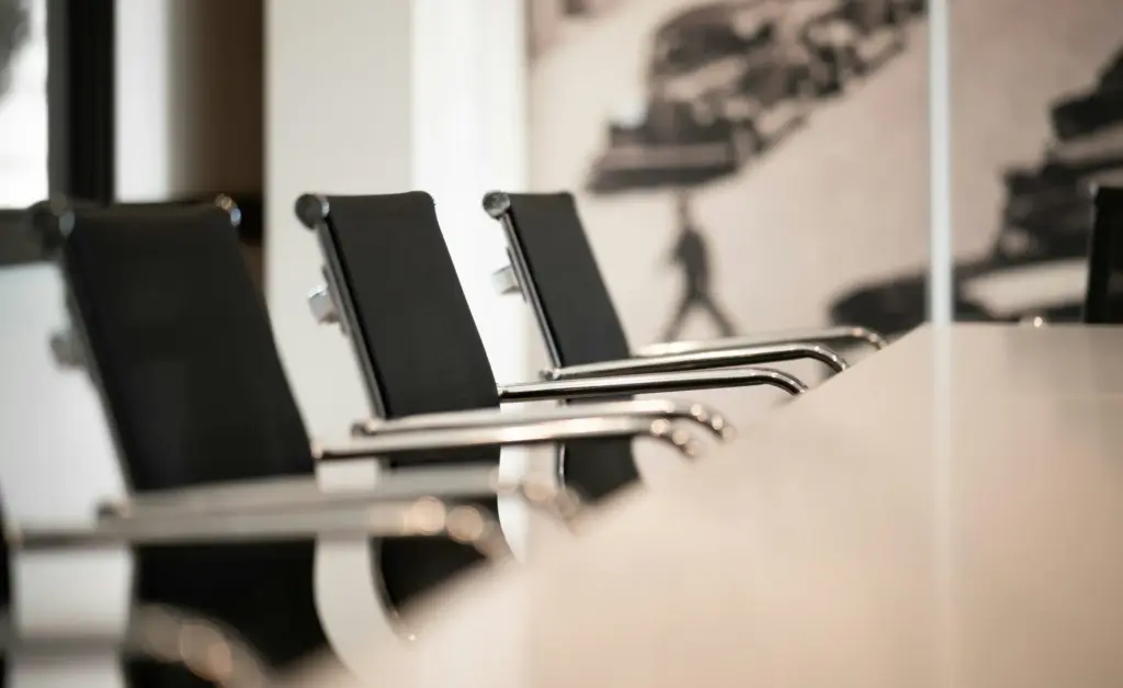 Zwarte bureaustoelen aan een vergadertafel