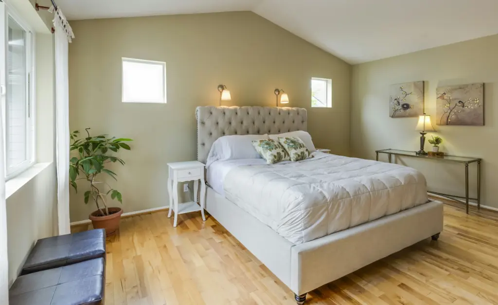 Slaapkamer met een gecapitonneerd wit bed