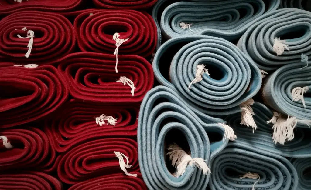 Opgerolde tapijten in rood en blauw naast elkaar