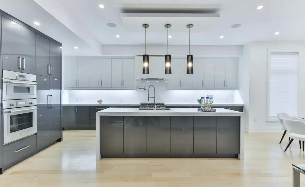 Moderne keuken op maat met grijze kasten, kookeiland en houten vloer