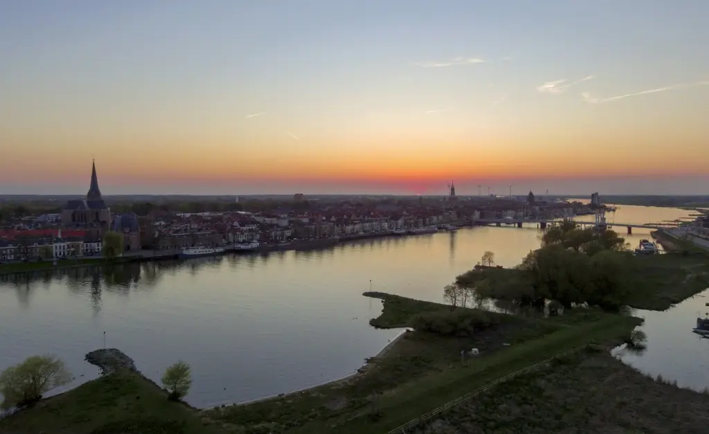Stad aan de rivier bij zonsondergang