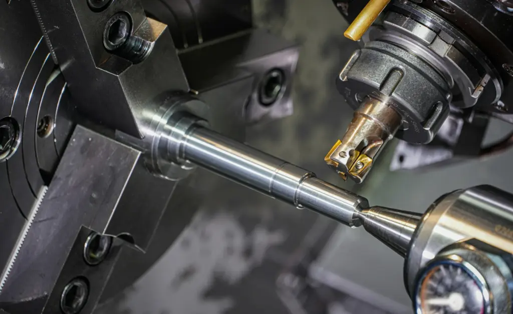 Metalen as die op een draaibank wordt bewerkt